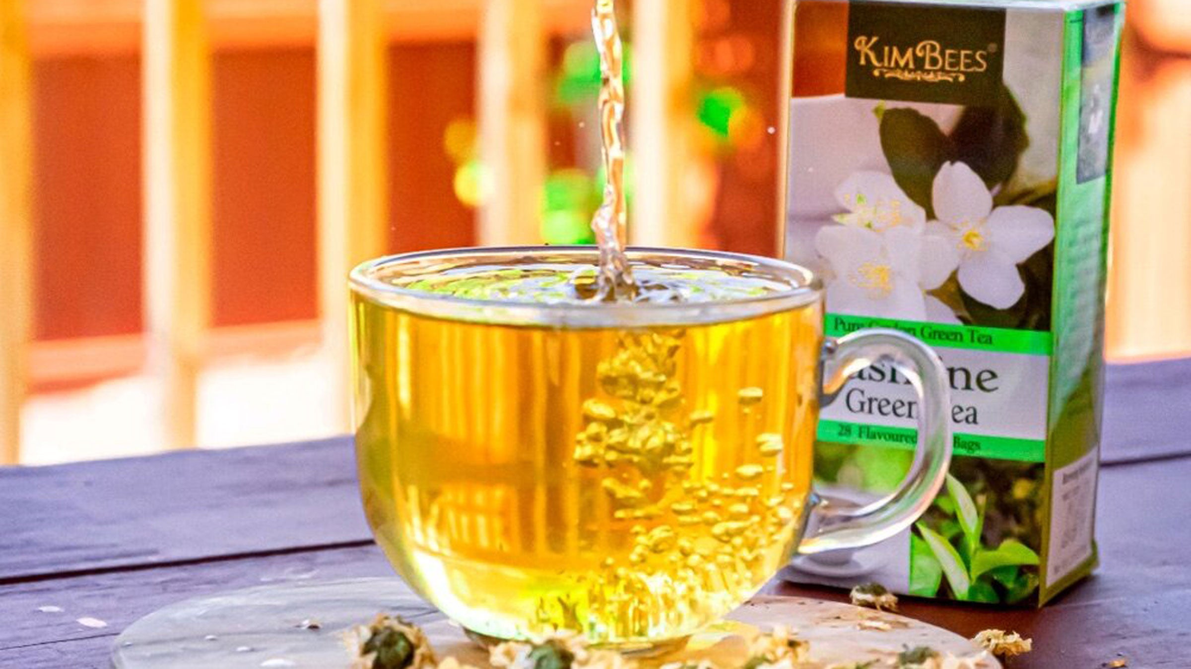 Green tea being poured into a clear mug