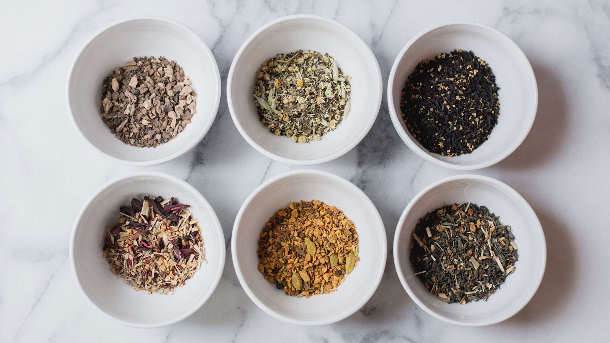 Six assorted loose leaf teas in white dishes